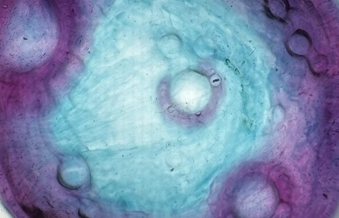 A cropped image of resin moon with purple and teal whirls